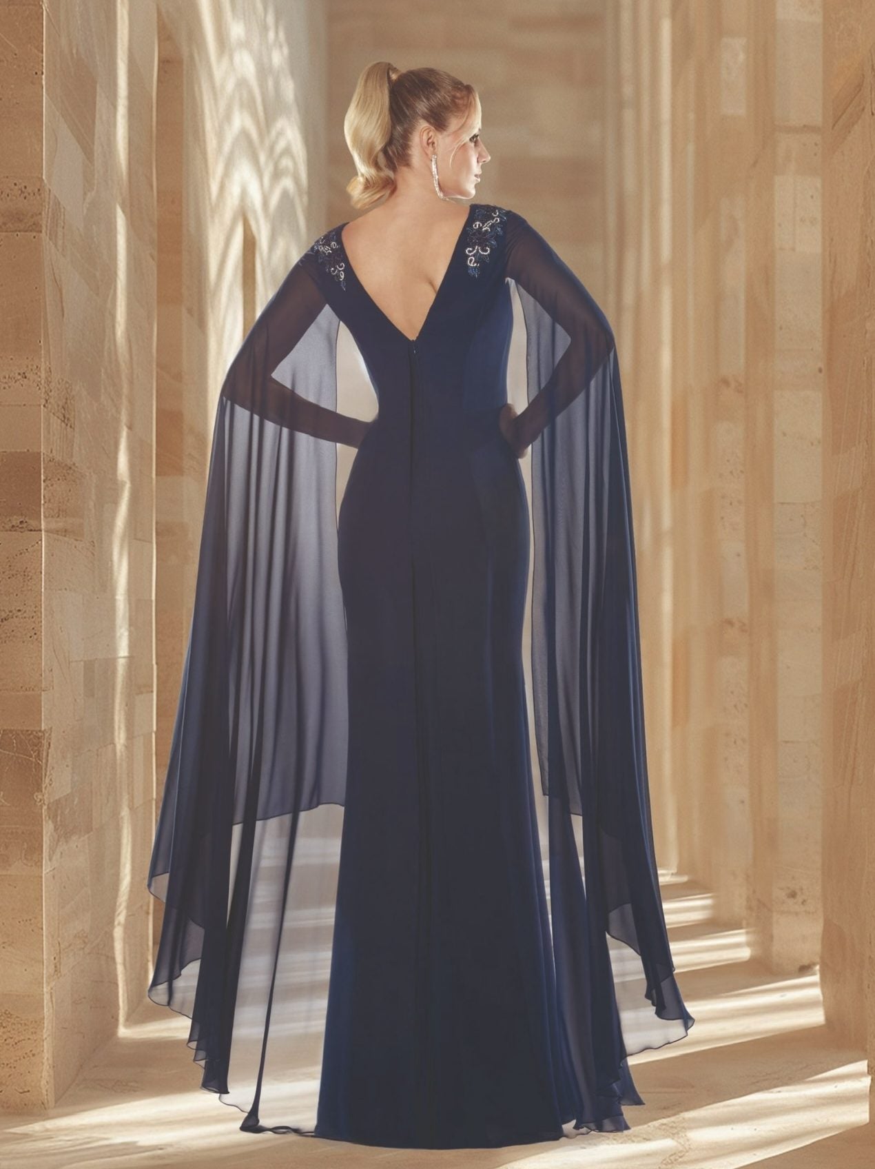 Vestido largo de pedrería con manga en forma de capa y espalda descubierta