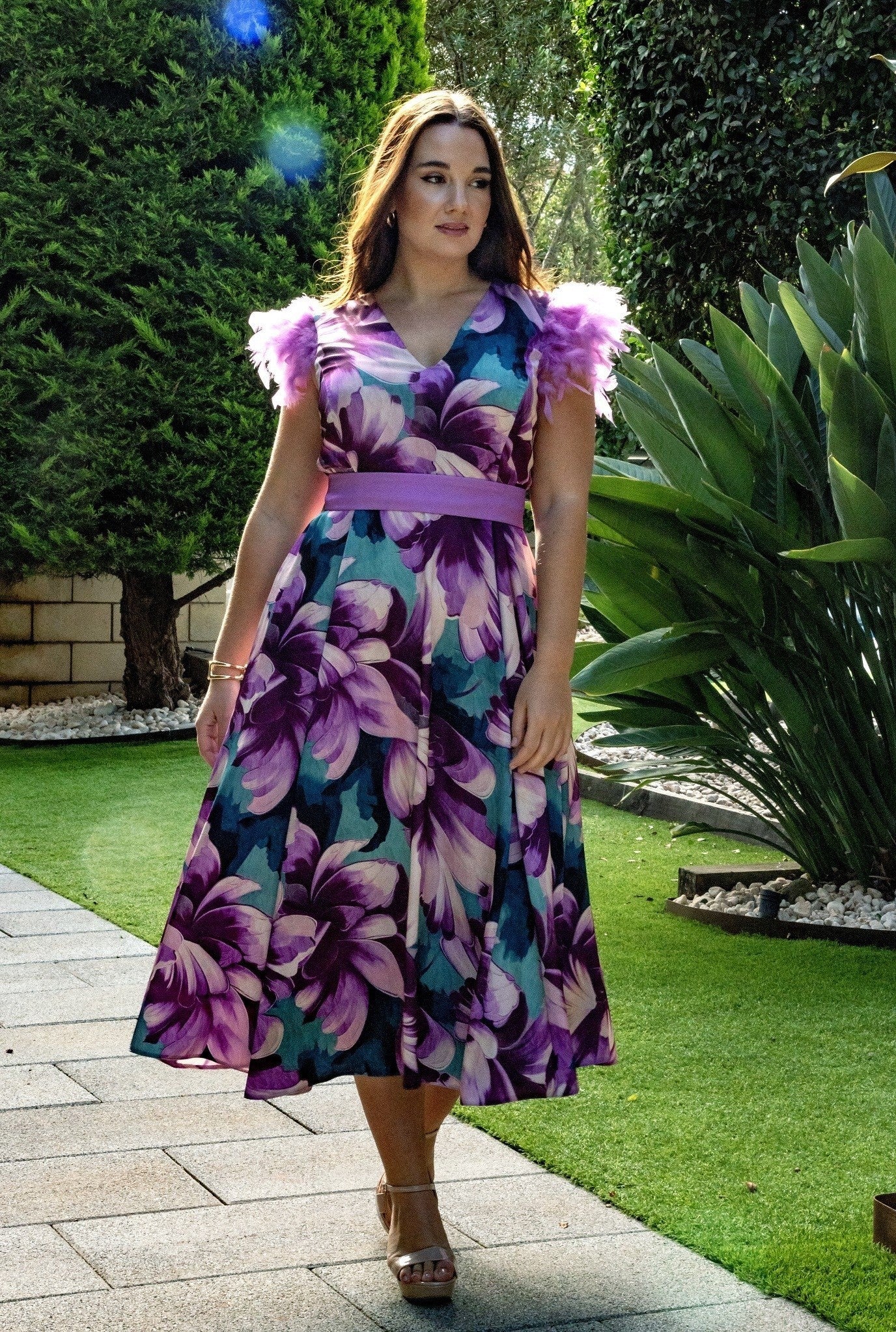 Vestido largo estampado con abertura lateral y plumas en los hombros.