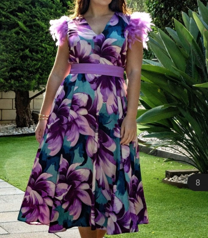 Vestido largo estampado con abertura lateral y plumas en los hombros.